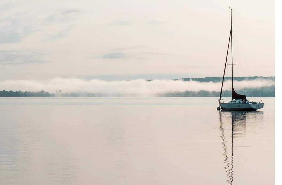 Segelboot auf dem Ammersee, Nebelband über dem gegenüberliegenden Ufer